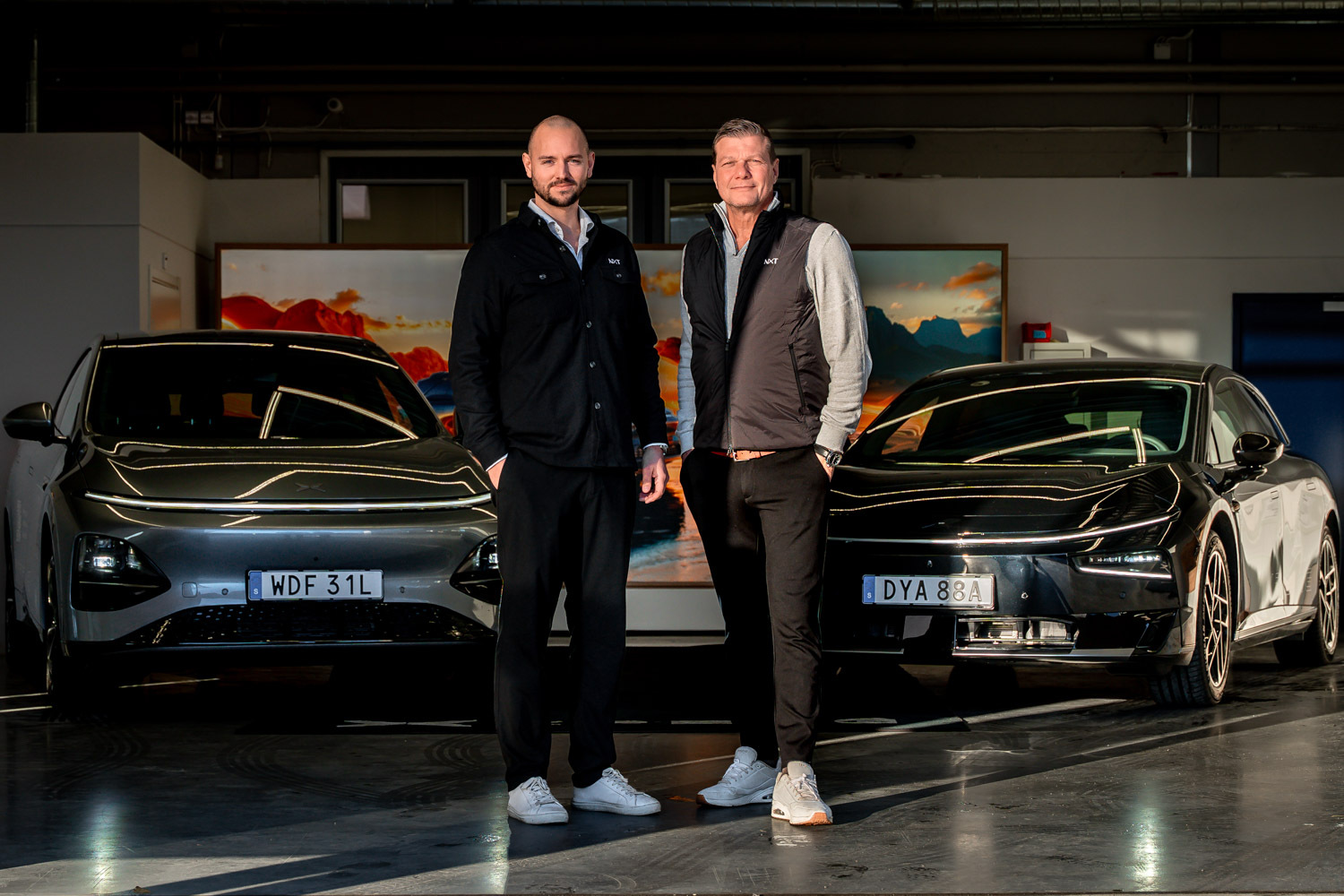 Två medarbetare från NXT by Motorcentralen tillsammans med XPENG-bilar.